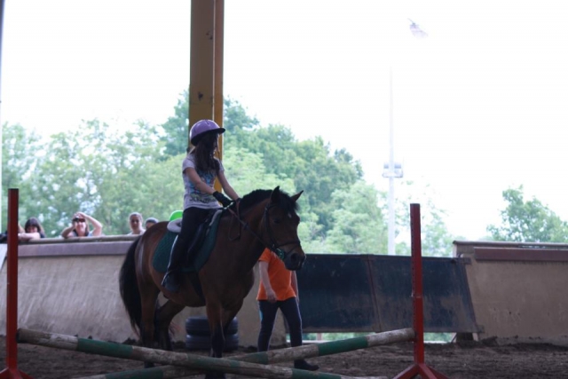  Beginner girl riding a pony with helmet